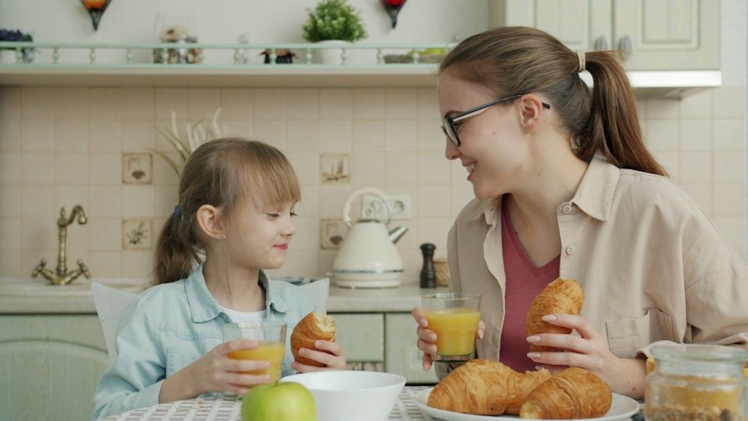 Vuxen och barn äter frukost lugnt tillsammans i köket